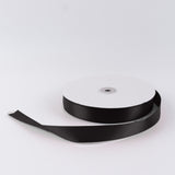 Black satin ribbon spool on white background