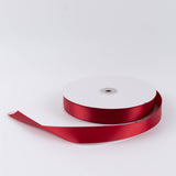 Red satin ribbon spool on white background