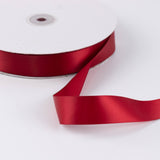 Red satin ribbon spool on white background