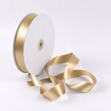 Gold satin ribbon spool on white background