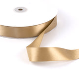Gold satin ribbon spool on white background