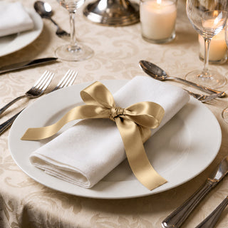 Elegant gold ribbon napkin on white plate at formal dinner table