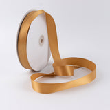 Gold satin ribbon roll on spool with loose ribbon end