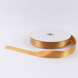 Gold satin ribbon spool on white background