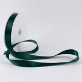 Dark green satin ribbon spool on white background