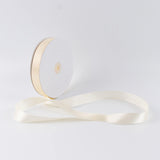 Ivory satin ribbon spool with ribbon unrolled on white background
