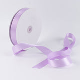 Lavender satin ribbon spool with ribbon flowing on white background