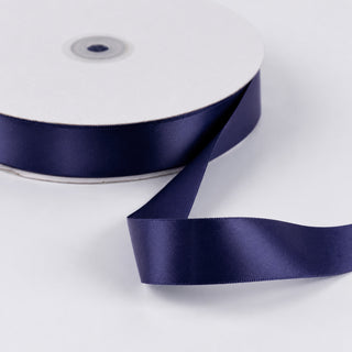 Navy blue satin ribbon spool on white background