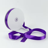 Purple satin ribbon spool on white background