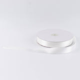 White satin ribbon spool on a white background