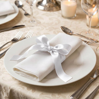 Elegant white napkin tied with ribbon on a formal dining table setting