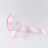 Pink satin ribbon spool on white background