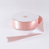 Pink satin ribbon roll with iridescent sheen on white background