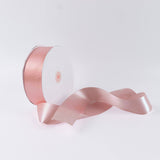 Pink satin ribbon spool on white background