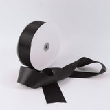 Black satin ribbon spool on white background