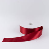 Red satin ribbon spool on white background