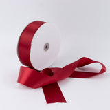 Red satin ribbon roll with loose ribbon on white background
