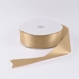 Gold satin ribbon spool on white background