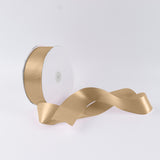 Gold satin ribbon spool on white background with flowing ribbon