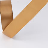Gold satin ribbon on white background, close-up decorative craft material