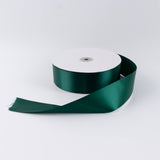 Dark green satin ribbon spool on white background