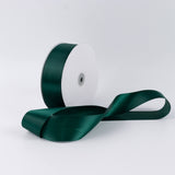 Dark green satin ribbon spool on white background