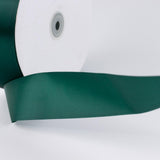 Green satin ribbon spool on white background