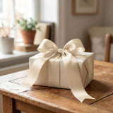 Elegant white gift box with satin ribbon on a wooden table