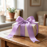 Gift box with lavender ribbon bow on rustic wooden table