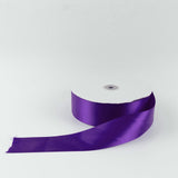 Purple satin ribbon spool on a white background