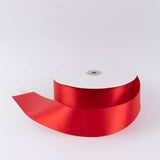 Red satin ribbon spool on white background