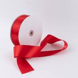 Red satin ribbon spool on white background