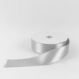 White satin ribbon spool on a plain background