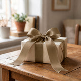 Elegant wrapped gift box with satin bow on a wooden table
