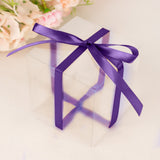 Transparent gift box with purple ribbon and soft floral background