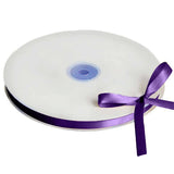 White satin ribbon spool with purple ribbon and bow