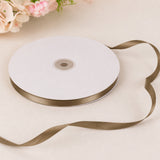 White satin ribbon roll with gold edge on neutral background
