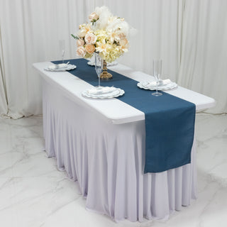 Elegant table setting with blue runner, floral centerpiece, and glassware.
