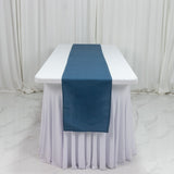 Blue table runner on a white tablecloth in a studio setting.