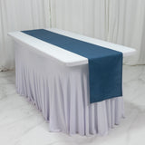 Navy table runner on a white tablecloth in a studio setting.