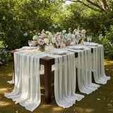 Elegant outdoor dining setup with floral arrangements and draped table linens.