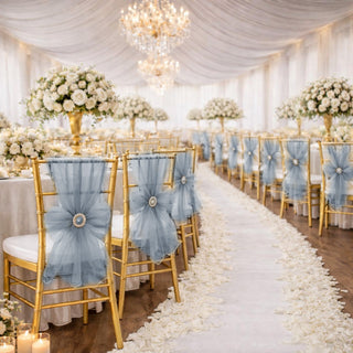 Elegant wedding reception with gold chairs, blue tulle bows, and white floral decor