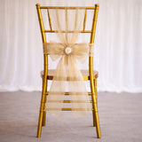 Gold chiavari chair with a cream bow on the back.