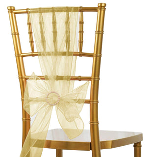 Gold chiavari chair with sheer yellow sash and bow on a white background.