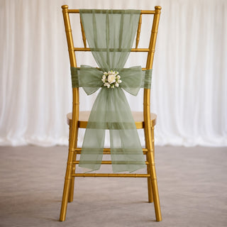 Gold chiavari chair with sage green sheer sash and floral centerpiece