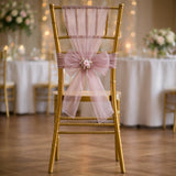Gold chiavari chair with pink sash and flower decoration in elegant event setting.