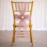 Gold chiavari chair with a blush bow and flower detail, elegant decor accent.