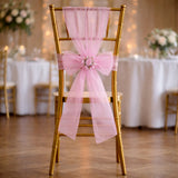 Gold chiavari chair with pink tulle sash and floral embellishment.