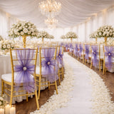 Elegant wedding reception setup with floral arrangements and purple chair sashes.