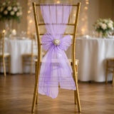 Gold chiavari chair adorned with lavender organza drape and floral bow.